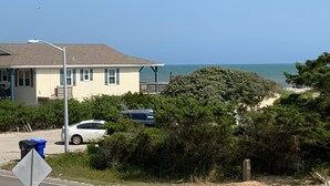 A coastal house with a view of the ocean, a streetlight, and parked cars. - *Beach House!!*Views!!*Steps to Ocean!*Amenities! (Oak Island)