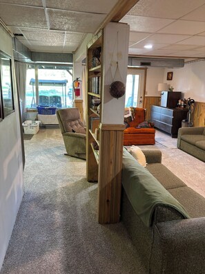 A cozy living room with a sofa, a chair, a bookshelf, and a small table.