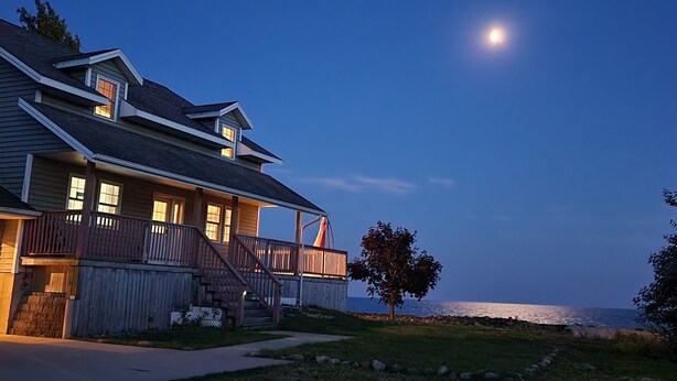 Une maison à deux étages avec un balcon et vue sur l’océan.