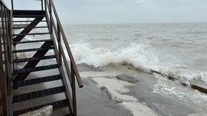 Un escalier métallique menant à une jetée d’où l’on a une vue sur l’océan.
