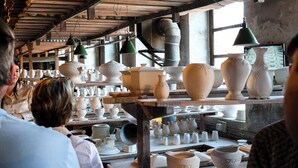 Un atelier de poterie où l’on peut admirer, sur des étagères, toute une collection de vases et de bols en céramique blanche.