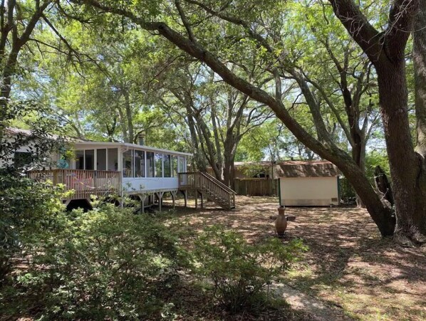 Escape to a secluded cabin surrounded by nature, with a porch and staircase leading to a peaceful retreat.