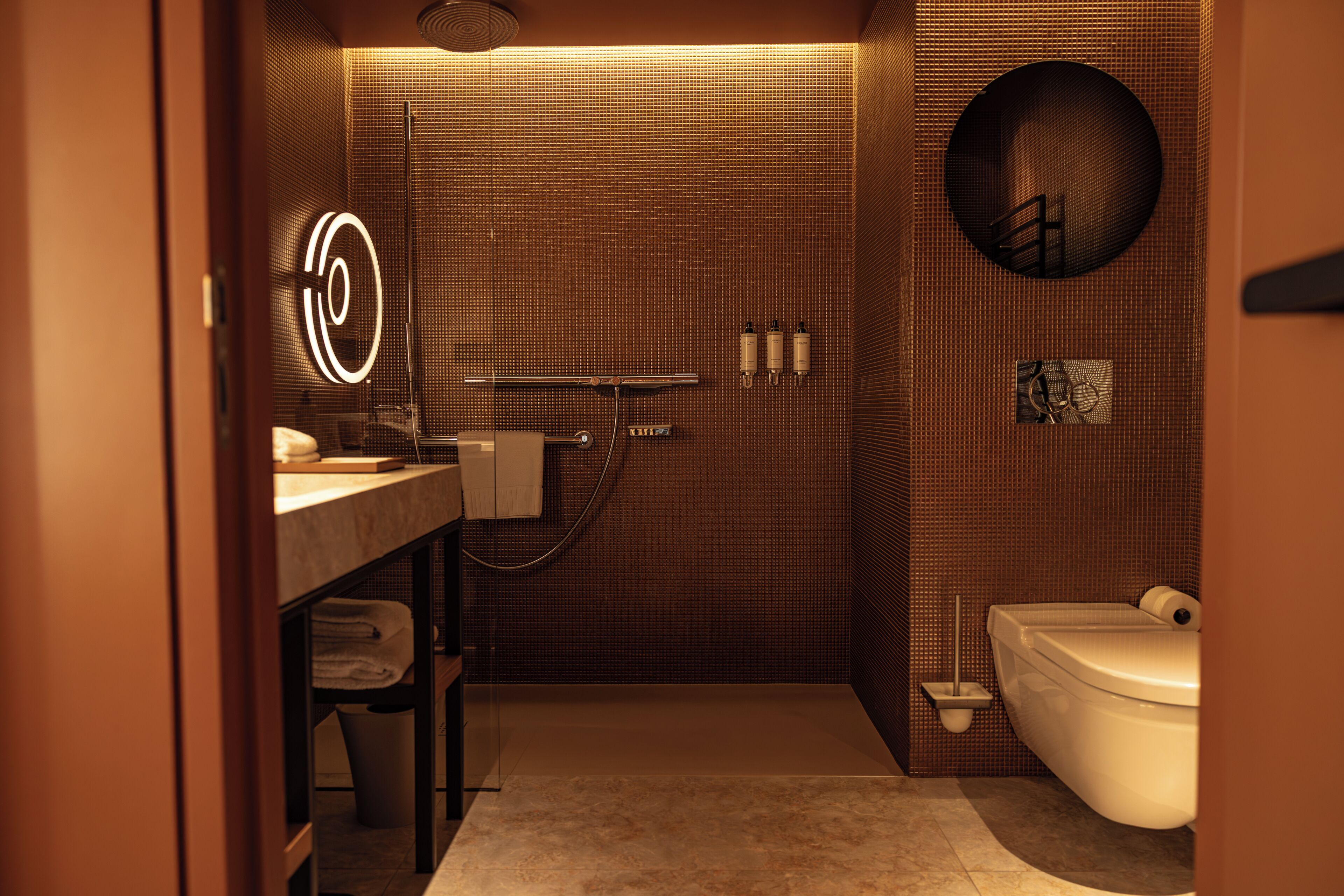 A modern bathroom with a shower, toilet, and sink.