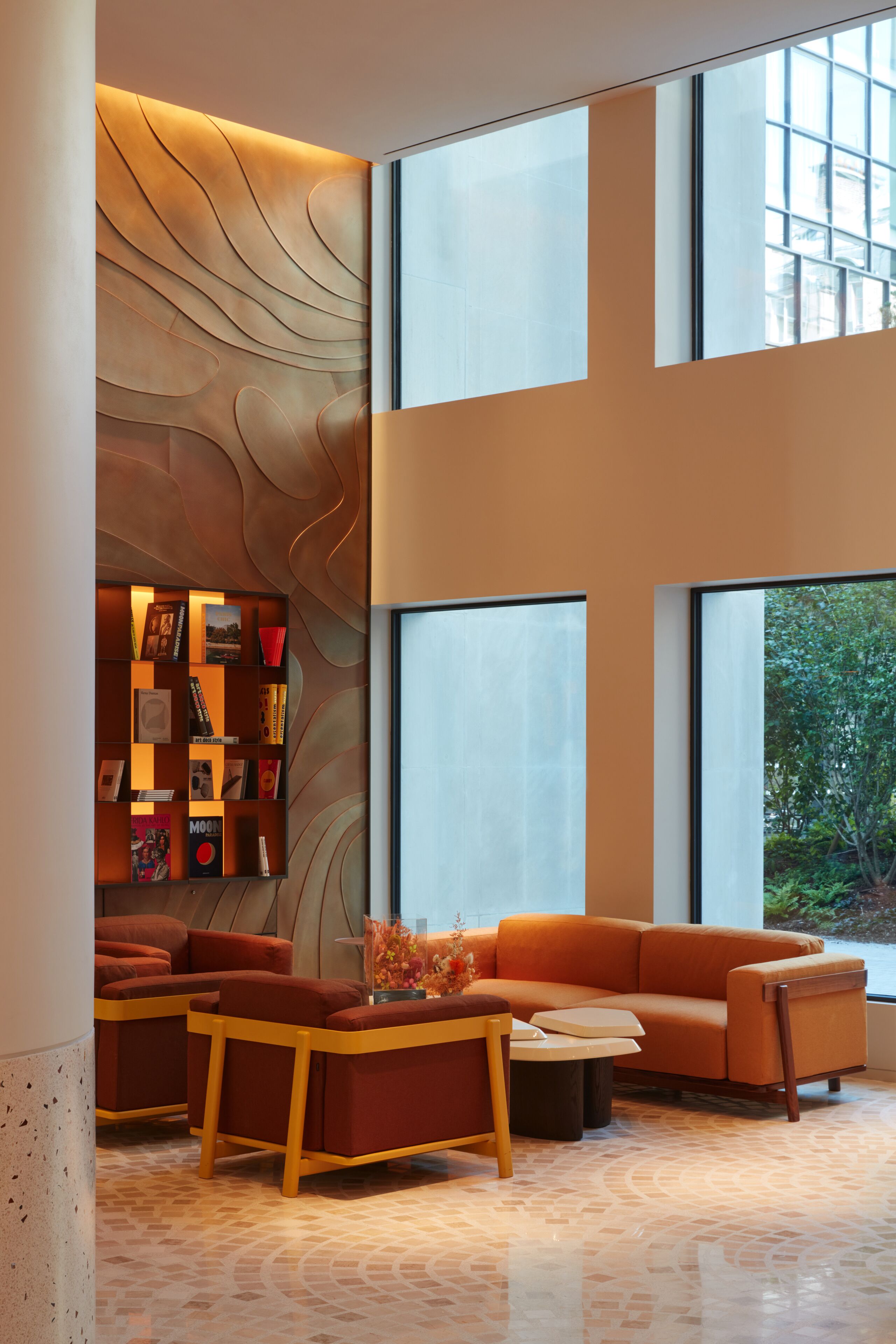 Un intérieur moderne avec un canapé d’angle, une table basse en bois et une bibliothèque.