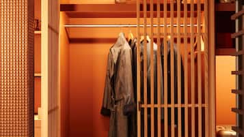 A walk-in closet with a wooden partition, shelves with clothes, a suitcase, and a helmet.