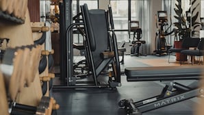 A gym with exercise equipment, a bench, and a treadmill.