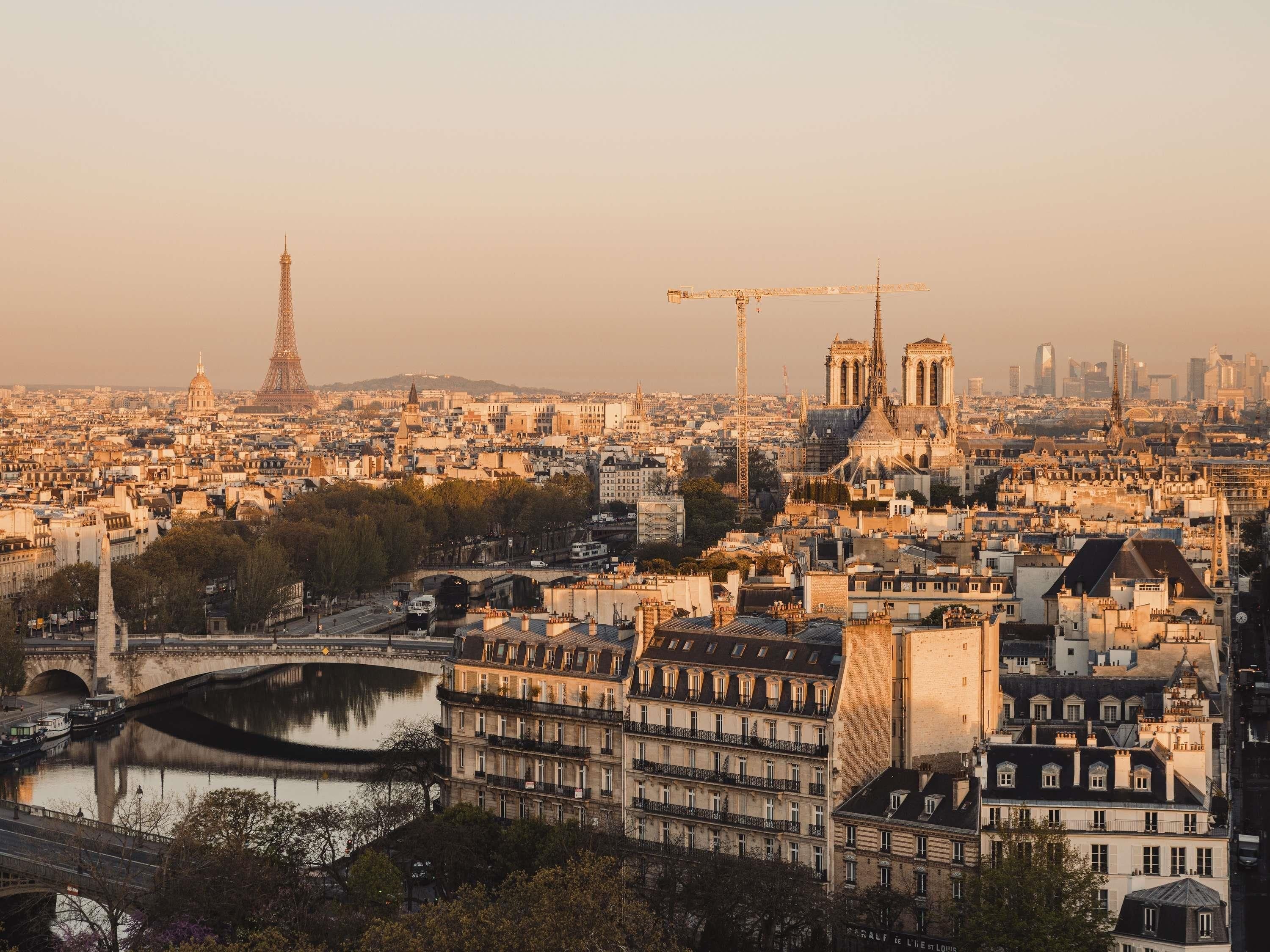 A cityscape with the Eiffel Tower, Notre-Dame Cathedral, and a river.