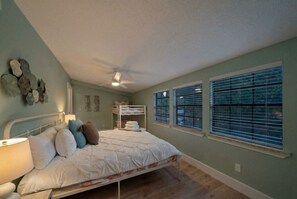 A bedroom with a bed, bedside lamp, and a ceiling fan. - Cozy Home Near Kemah Boardwalk with Game Room (Kemah Area)
