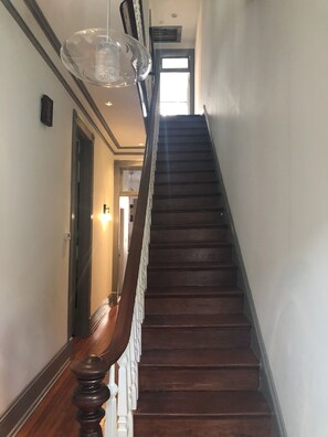 Staircase leads to an upper floor with a door and glass enclosure.