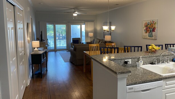 A modern kitchen with a granite countertop, white cabinets, and a built-in dishwasher. - Ocean Keyes 3 BR Condo, XL balcony, pool, 1 block to beach, food,  & famous OD (North Myrtle Beach)