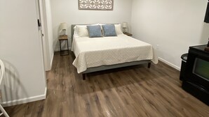 A bedroom with a bed, a TV, and a decorative wall piece.