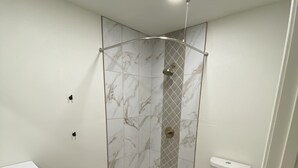 A bathroom with a shower, toilet, and sink.