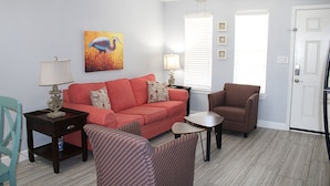 A living room with a sofa, armchairs, a coffee table, and a painting on the wall. - Modern retreat on the water (Rockport)