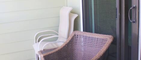 A patio area with wicker furniture and a sliding glass door.