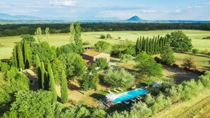 Una extensa propiedad con piscina, una casa y una montaña al fondo.