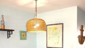 Un comedor con mesa, sillas, lámpara colgante y adornos en la pared.