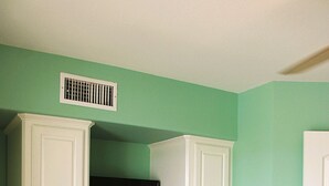 A bedroom with a bed, a television on a cabinet, and a door. - Second floor condo with canal view (Rockport)