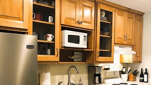A kitchen with wooden cabinets, a stainless steel refrigerator, a microwave, a dishwasher, a sink, and a stove. - Fantastic water view from comfortable cozy condo (Rockport)