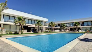 A modern hotel with a swimming pool, outdoor seating, and palm trees. - Modern, large terrace, pool and BBQ (Mar de Cristal)