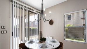 A dining area with a round table, chairs, and a chandelier. - "THE HAMPTON" Gilbert I Designer Style + Comfort I 3bed/2.5bath (Gilbert)