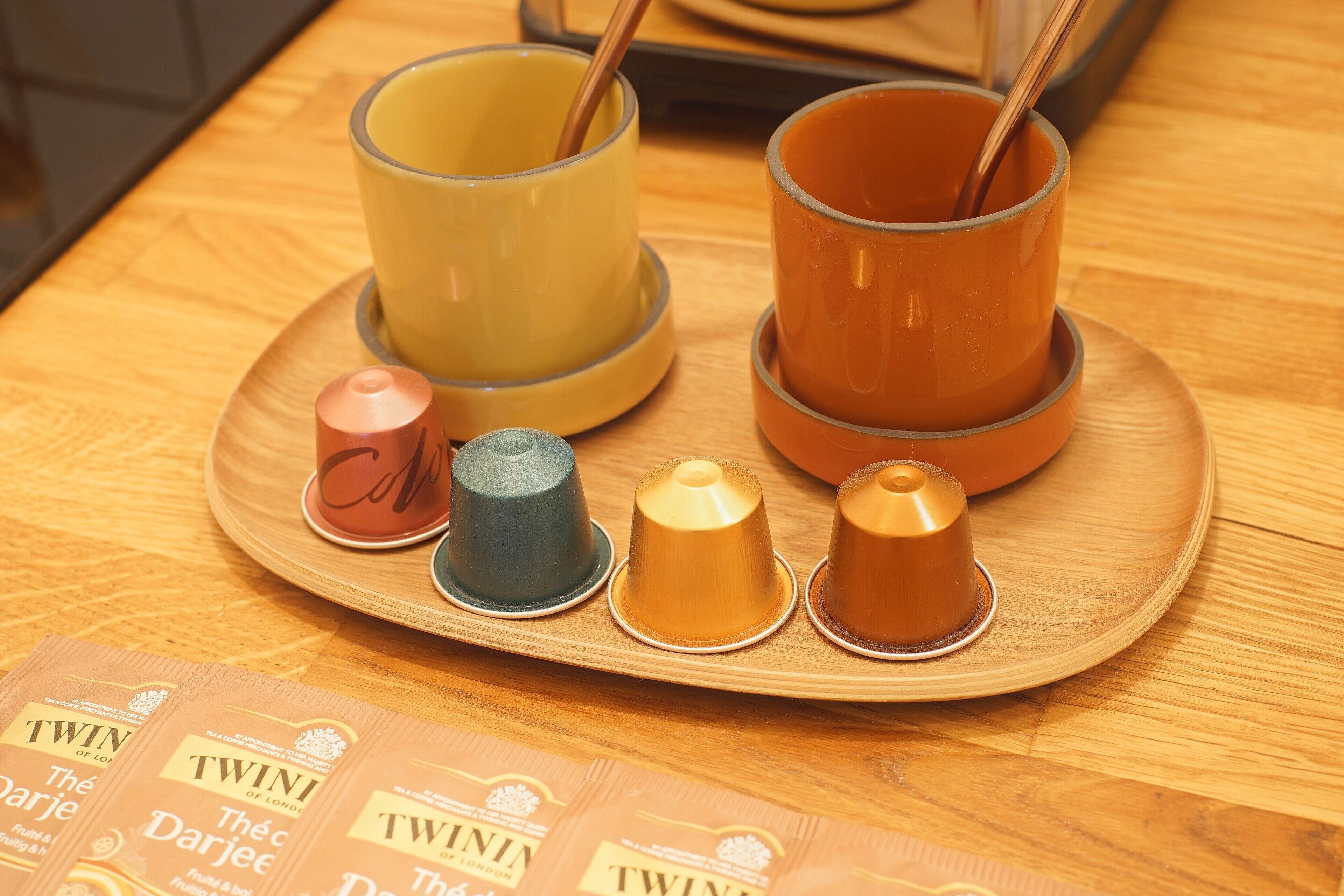 A tray with four cups and saucers, and four packets of Twinis coffee.