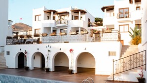 A hotel with a pool, multiple balconies with plants, and a staircase leading to the upper floors. - Turgutreis Apart Otel (Bodrum)