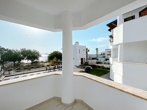 A balcony with a view of a playground, a white building, and a clear sky. - Turgutreis Apart Otel (Bodrum)