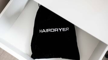 A white drawer with a black hairdryer inside.