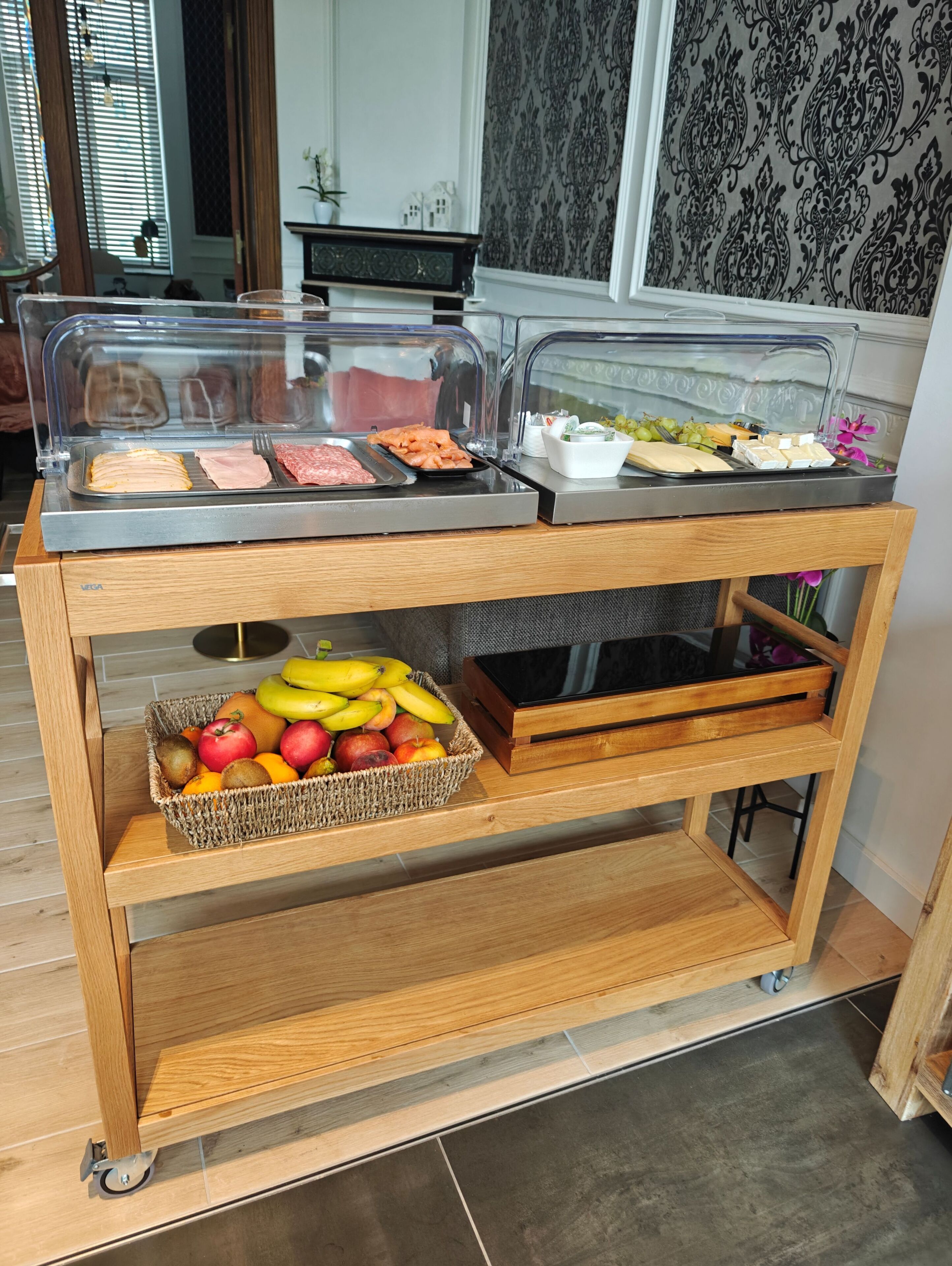 Montaje de bufé con diversos alimentos y una cesta de frutas.