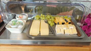 A buffet with cheese, grapes, and yogurt.