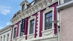 A historic building with a prominent 'HOTEL' sign, large windows, and classic architectural details. - Hotel L'ARTiste (Lessines)