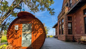 Un edificio in legno con una porta circolare, una panchina e un edificio in pietra sullo sfondo.