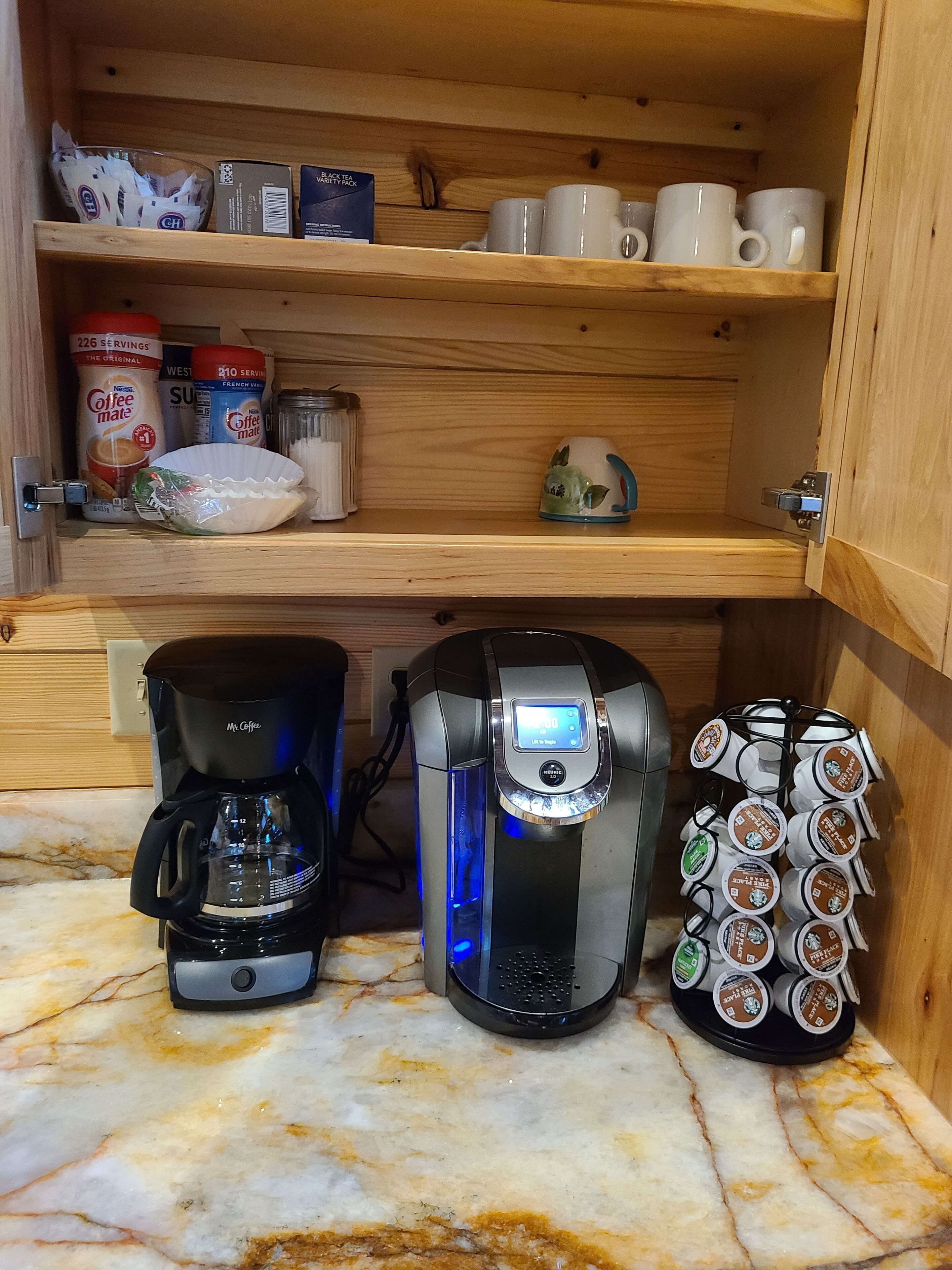 Una cocina con cafetera, máquina de café Keurig y un portalápices para cápsulas de café.