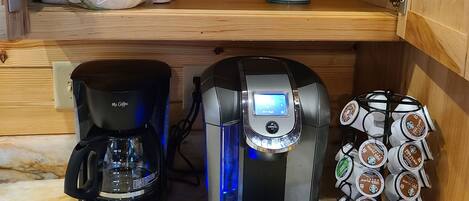 Una cocina con cafetera, máquina de café Keurig y un portalápices para cápsulas de café.