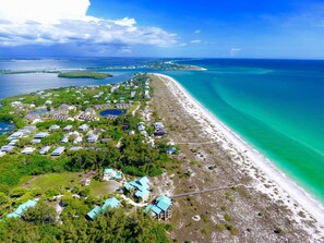 An aerial view of a coastal resort with beachfront properties, a marina, and clear turquoise waters. - Come Relax in the Sunshine, Sand, and Solitude of this Quiet Island Paradise (Placida)