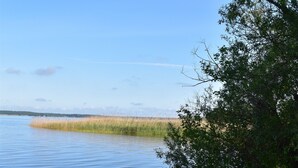 A bench by a calm body of water with a clear sky.