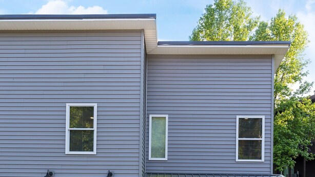 A two-story house with a grey exterior, a garage, and a front door marked with the number 257.