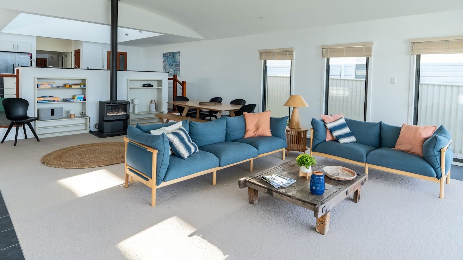A modern living room with a sofa set, a coffee table, and a fireplace.