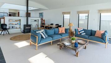 A modern living room with a sofa set, a coffee table, and a fireplace.