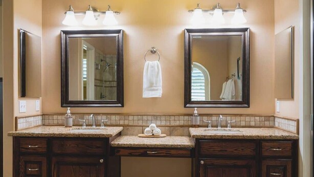 Une salle de bain avec deux lavabos, un porte-serviettes et un miroir.