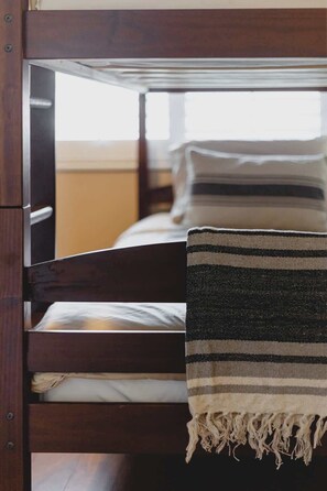 Un lit superposé avec une couverture à rayures jetée sur le lit du bas.