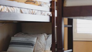 Un lit superposé avec une tête de lit, des oreillers et une couverture.