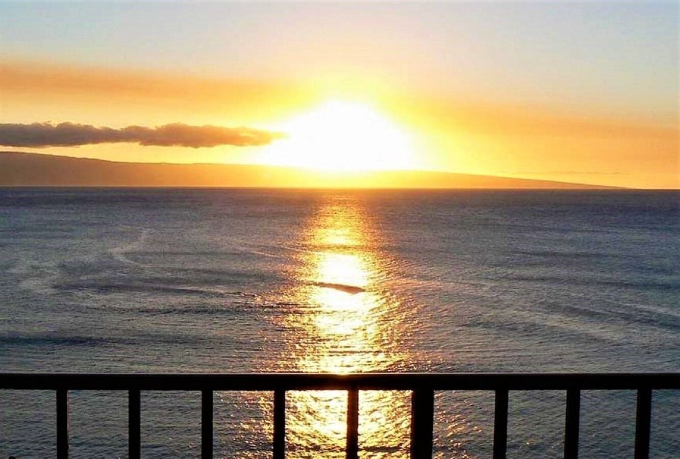 A sunset over the ocean with a view of the horizon.