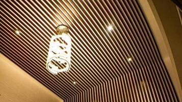 Un interior moderno con techo curvo, una lámpara central y un área de estar con una plataforma baja y escalonada.