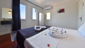 Ein Hotelzimmer mit einem Bett, einem Nachttisch, einem Spiegel und einem Fenster.