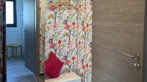 A room with a wooden door, a bench with a red cushion, and a mirror above it. There is a small table and a stool in the background. - Feel-good accommodation, starting point for mountain bike tours and hikes (Höhn)
