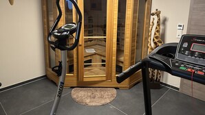 A gym with exercise equipment, a wooden cabinet, and a giraffe decoration. - Feel-good accommodation, starting point for mountain bike tours and hikes (Höhn)