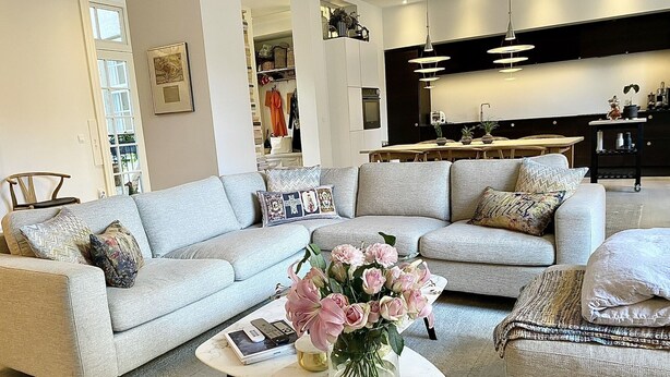 A modern living room with a grey sectional sofa, a marble coffee table, and a vase of flowers. - Spacious luxury apartment in city Center . (Copenhagen)