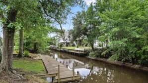 Une vue sur la rivière, avec un quai en bois menant à une maison.