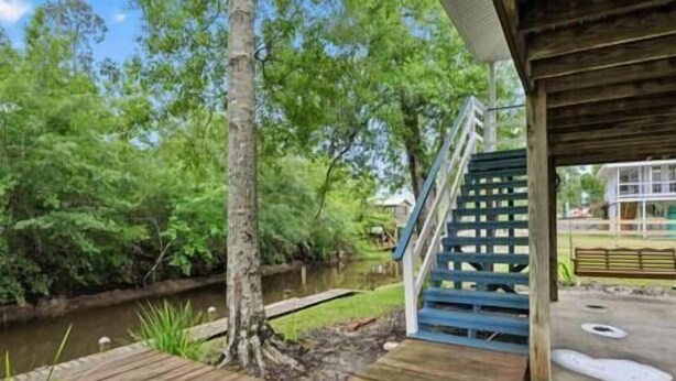 Une terrasse en bois avec un escalier menant à une zone abritée.